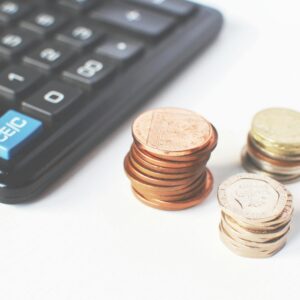 Close-up of stacked coins and a calculator symbolizing financial strategy and budgeting.