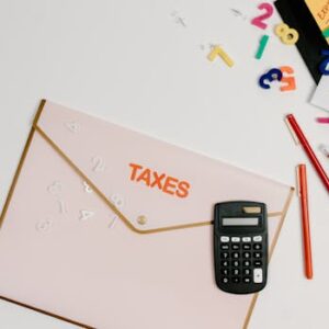Flat lay of a tax preparation workspace with calculator, envelope, and colorful numbers.